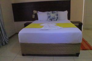 una camera da letto con un grande letto con lenzuola bianche di The upperroom bed and breakfast a Francistown