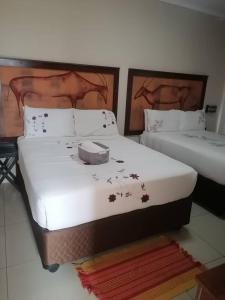 2 Betten in einem Zimmer mit 2 Betten in der Unterkunft The upperroom bed and breakfast in Francistown