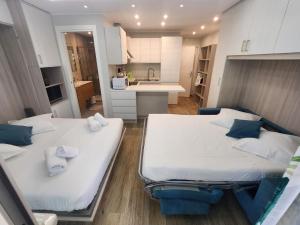 two beds in a small room with a kitchen at Bluemarine, studio vista Mare in Menton
