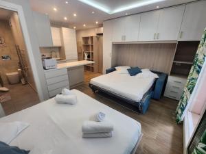 a small room with two beds and a kitchen at Bluemarine, studio vista Mare in Menton +8 photos