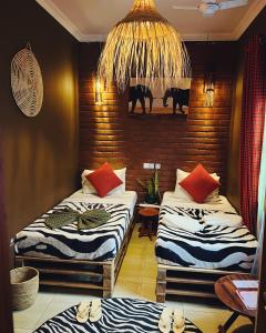 Cette chambre comprend deux lits et un lustre. dans l'établissement Savannah House, à Arusha