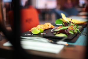 a black plate with food on a table at Stay inn Hotel Gdańsk in Gdańsk