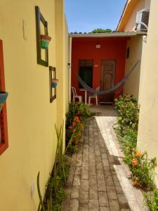 ein Gehweg führt zu einem Haus mit einer roten Tür in der Unterkunft Pousada Dos Cajueiros in Paripueira
