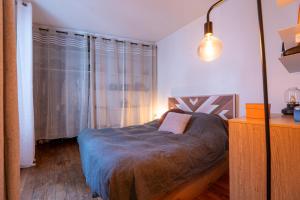 a bedroom with a bed and a lamp and a dresser at Appartement parisien (12ème) in Paris