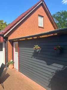 een huis met twee bloempotten aan de zijkant bij Nele in Klütz