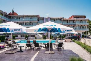 a patio with chairs and umbrellas and a pool at Хотел и Вили Марая apartament in Tsarevo