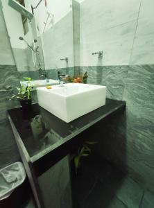 uma casa de banho com um lavatório branco e um espelho. em Kai Kazee Ella em Ella
