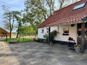 een wit huis met een rood dak en een patio bij Horse and Hound in Riethoven