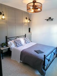 1 dormitorio con 1 cama con manta azul y lámpara en Villa Otivar, en Otívar