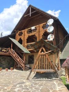 a large wooden building with clocks on the side of it at Trembita готель in Yablunytsya