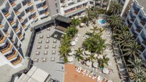 una vista aérea de un patio del hotel con sombrillas y palmeras en Servatur Don Miguel - Adults Only en Playa del Ingles