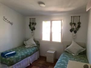 two twin beds in a room with a window at Bungalow Carmen in San Bartolomé +17 photos