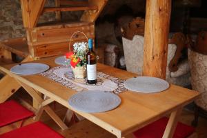 una mesa de madera con una botella de vino y flores. en Mountain view Lodges en Žabljak