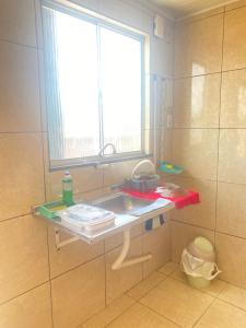 a small bathroom with a sink and a window at Flats com cozinha in Feira de Santana