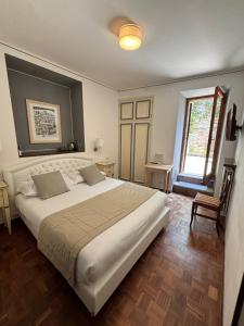 a bedroom with a large white bed and a window at Hotel La Fortezza in Assisi