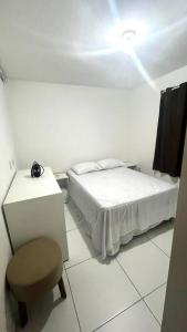 um quarto com uma cama, um banco e uma luz em Apto Ipojuca Caruaru em Caruaru