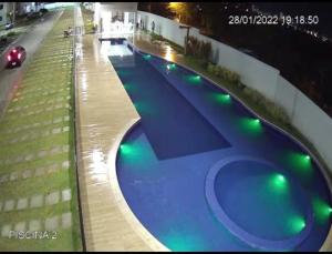 a swimming pool with green lights on the side of a building at Apto Ipojuca Caruaru in Caruaru