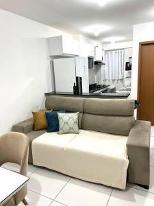 a couch in a living room with a kitchen at Apto Ipojuca Caruaru in Caruaru