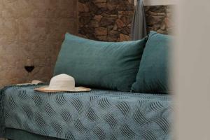kapelusz na górze łóżka z poduszkami w obiekcie Pyrgi house, Ipsos Corfu w mieście Ýpsos