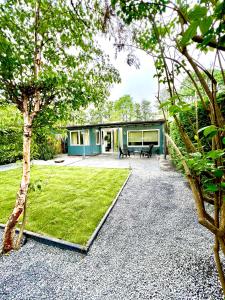 a house with a garden with a bench in the yard at Cozy family house with spacious garden in the nature near Amsterdam in Vijfhuizen