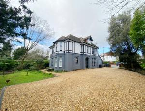 a large white house with a large driveway at Sail Away. 1-Bed apartment close to the beach in Bournemouth