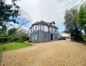 a large white house with a large driveway at April Lodge Sail Away- 1Bed apartment close to the beach-Parking-Couples-Professionals-Contractors in Bournemouth