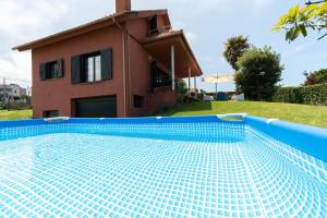 una villa con piscina frente a una casa en Casa Playa By Saianes, en Vigo