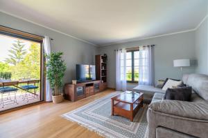 Una sala de estar con un sofá y un televisor. en Casa Playa By Saianes, en Vigo