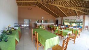 a dining room with green tables and chairs at Lindo Apartamento no Aldeia do Lago em Caldas Novas in Caldas Novas