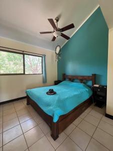 a bedroom with a bed with a ceiling fan at Tucan Studio Ocotal in Coco