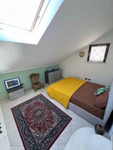 a bedroom with a bed with a yellow blanket and a rug at Sweet home Rosarno in Rosarno +21 photos