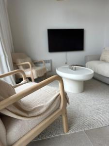 a living room with a tv and a chair at Appartement Sainte-Cécile in De Panne