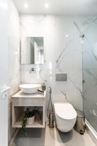 La salle de bains blanche est pourvue de toilettes et d'un lavabo. dans l'établissement Hotel Francesca, à Ágios Prokópios