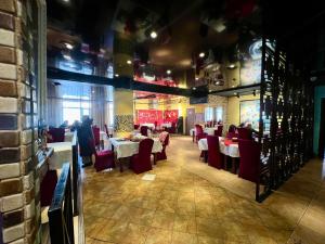a dining room with white tables and red chairs at Negdelchin Hotel & Service Apartment in Ulaanbaatar