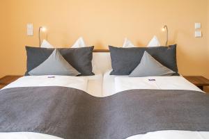 two beds with blue and white pillows in a room at Boutiquehotel zur Winzerstube - Adults Only in Hagnau
