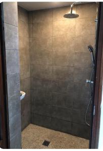 La salle de bains est pourvue d'une douche avec une porte en verre. dans l'établissement Ty case péi, à Saint-Aignan