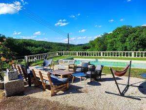 a patio with a table and chairs next to a pool at Gîte du ru d ausson in Avrigny