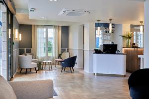 - une salle d'attente avec des chaises et une table dans l'établissement Quality Hotel La Marebaudière Vannes Centre, à Vannes