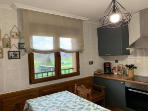 a kitchen with a table and a sink and a window at El Hoyaco in Los Espejos de la Reina