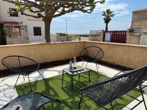 a patio with two chairs and a table with a drink at Maison toute équipée vue mer in Fleury