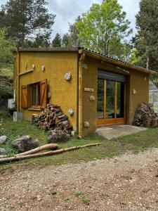 a house with a bunch of logs in front of it at Racons del Pedraforca in Saldés