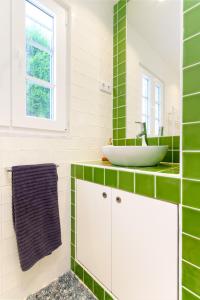 un bagno con piastrelle verdi e bianche e un lavandino di Salento ad Alcácer do Sal Altre 47 foto