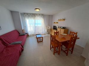 sala de estar con sofá rojo y mesa en Apartamentos Ágata V.v., en La Manga del Mar Menor