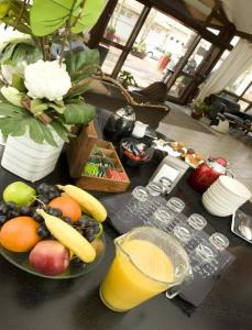a table topped with two bowls of fruit and juice at Enzo Hôtels - ST Eloy Metz Amneville By Kyriad Direct in Amnéville