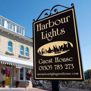 a sign for a guest house in front of a building at Harbour lights guesthouse room only in Weymouth