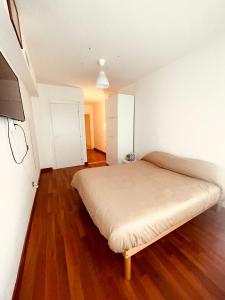 a small bedroom with a bed and wooden floors at cuore di caserta in Caserta