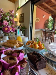 einen Tisch mit verschiedenen Brotsorten und Desserts in der Unterkunft L'Orto in San Vero Milis