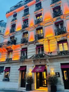 un grand bâtiment avec des lumières violettes et orange sur lui dans l'établissement Chalgrin Boutique Hotel, à Paris