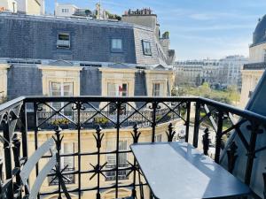- une table sur un balcon avec vue sur un bâtiment dans l'établissement Chalgrin Boutique Hotel, à Paris