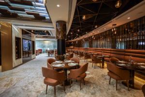 Golden Sands Boutique Hotel-Dubai Creek في دبي: مطعم بطاولات وكراسي وبار